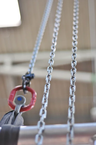 Cadeia de metal e um suporte de montagem vermelho — Fotografia de Stock
