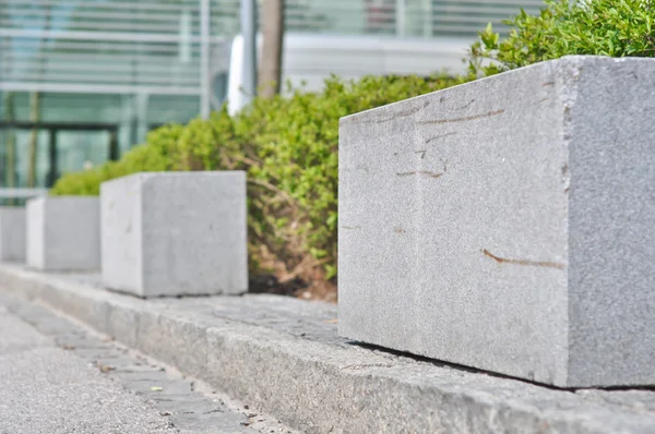 Rechthoekige graniet hek in de voorkant van struiken — Stockfoto