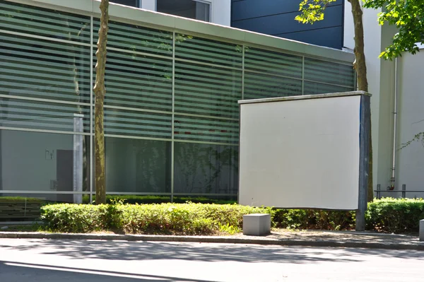 Panneau d'affichage blanc sur le fond d'un bâtiment moderne — Photo