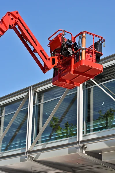 Kolebką czerwony hydrauliczne budowlane przeciw błękitne niebo — Zdjęcie stockowe