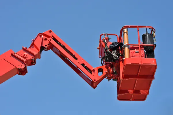 Piros hidraulikus építési bölcső ellen a kék ég — Stock Fotó