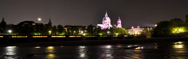 Vista noturna para o rio Isar e a igreja atrás dele, Munique, Alemanha — Fotografia de Stock