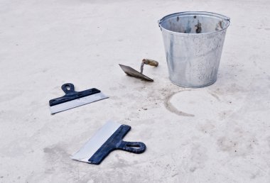 Metal bucket with cement and spatulas clipart