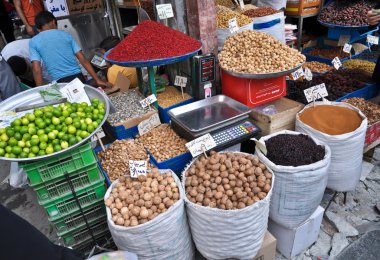 Spices and nuts on the scales and dishes in an old bazaar in Tehran, Iran clipart