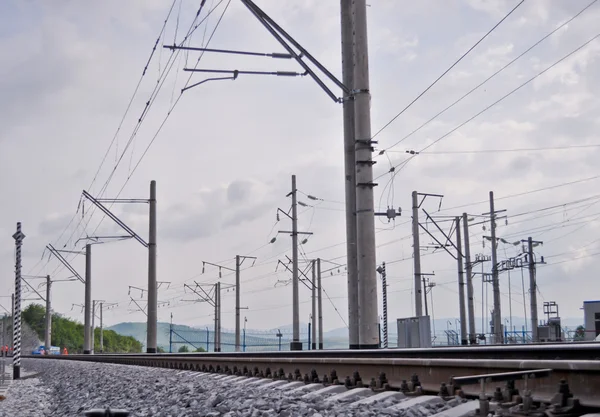 Rel kereta api, tanggul, dan tiang listrik — Stok Foto