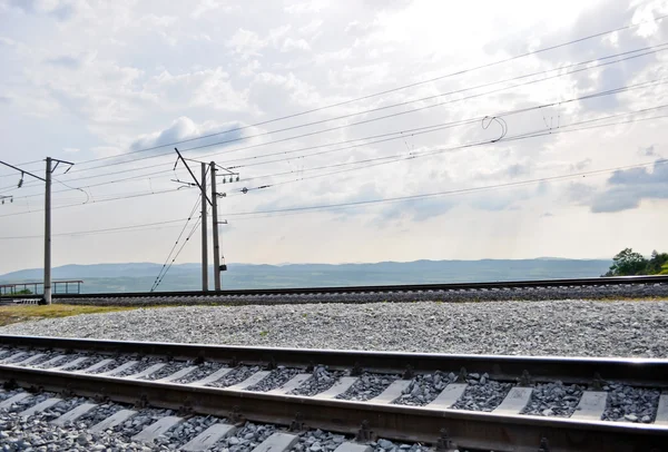 Rel kereta api, tanggul, dan tiang listrik — Stok Foto
