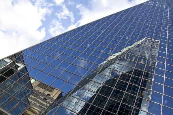 Weerspiegeling van gebouwen op een gebouw van glas — Stockfoto