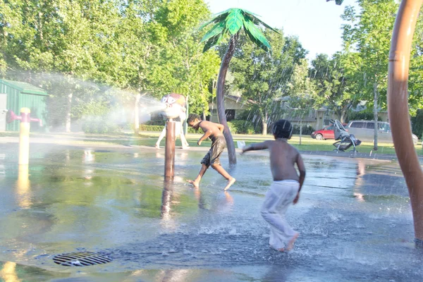 Kinderen spelen in een water splash park — Stockfoto