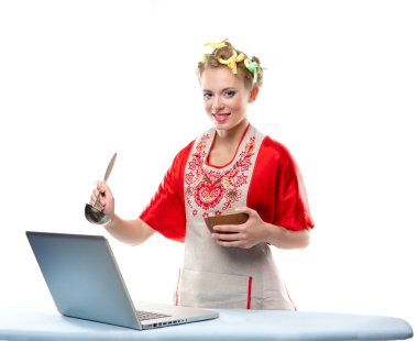 Woman is cooking with the recipe on a laptop clipart