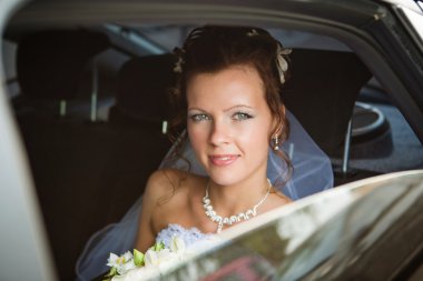 Portrait of a pretty bride in a car clipart