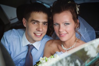 Portrait of a newlywed couple in a car clipart