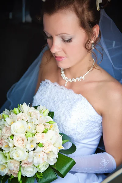 車の中でかなりの花嫁の肖像画一束鲜花和一个美丽的新娘的特写 — 图库照片