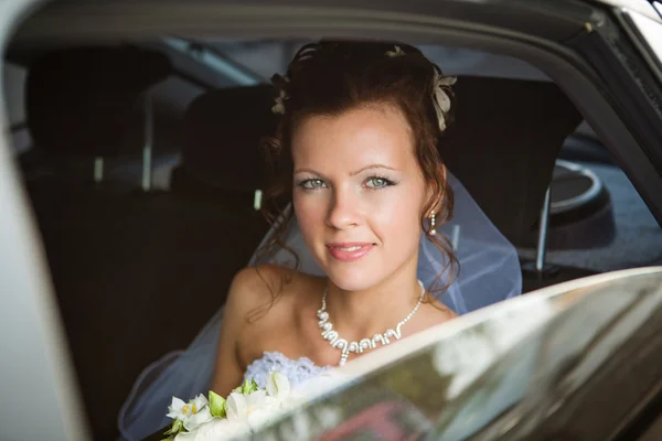 一个坐在车上的漂亮新娘的画像 — 图库照片