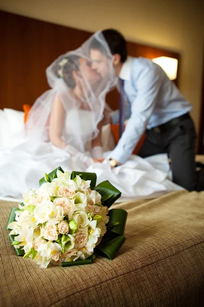 Novomanželský pár líbat navzájem v ložnici — Stock fotografie