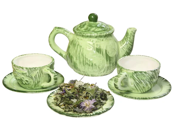 Зелений чайник з кубиками і сушеною травою на блюдці на білому фоні — стокове фото