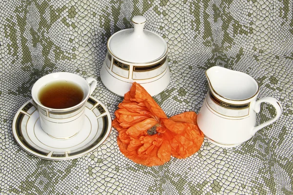 Μια κούπα τσάι, και ένα Κύπελλο ζάχαρης με ένα κόκκινο λουλούδι — Φωτογραφία Αρχείου