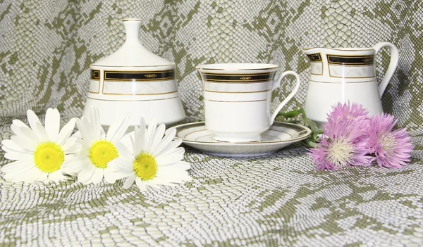 Uma caneca de chá uma tigela de açúcar com camomilas e flores silvestres rosa — Fotografia de Stock