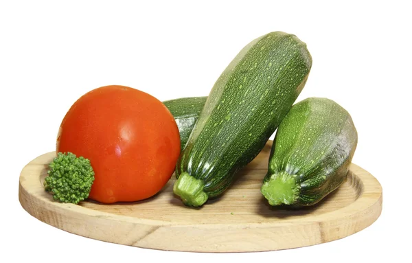 Cabbage of a broccoli and vegetable marrows on a wooden plate on a white ba — Stock Photo, Image
