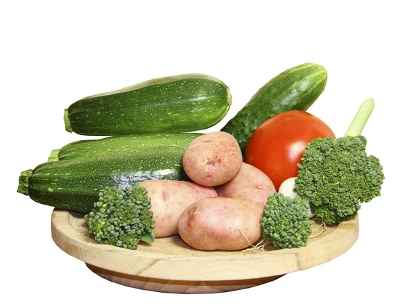 Verduras sobre un plato de madera sobre fondo blanco — Foto de Stock