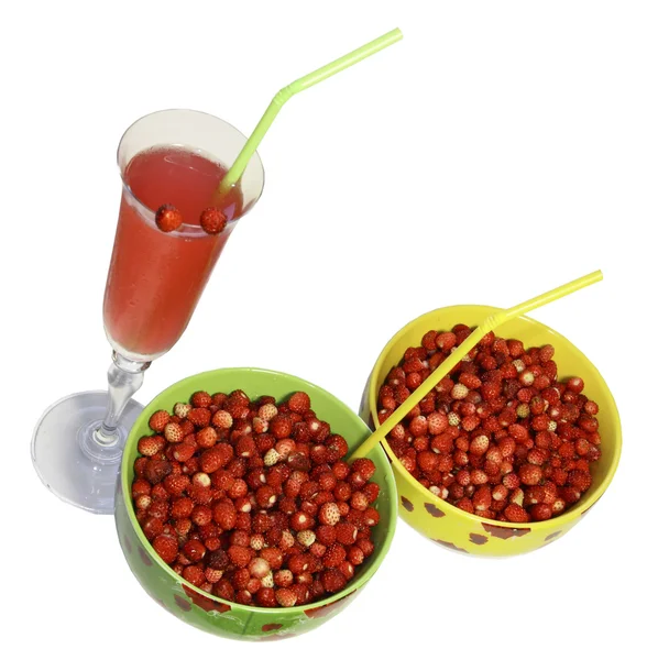 Дві круглі тарілки з ягодами дикої полуниці і склянкою соку з — стокове фото