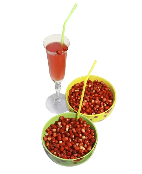 stock image Two round plates with berries of wild strawberry and a glass of juice with