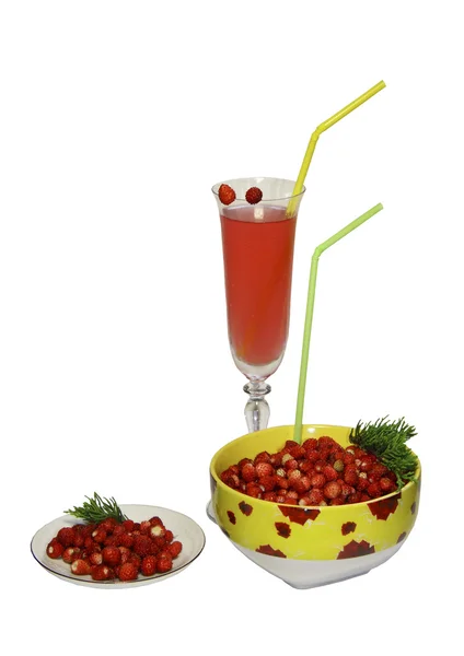 Stock image Wild strawberry berries in a plate, a saucer and a glass of juice with tubu