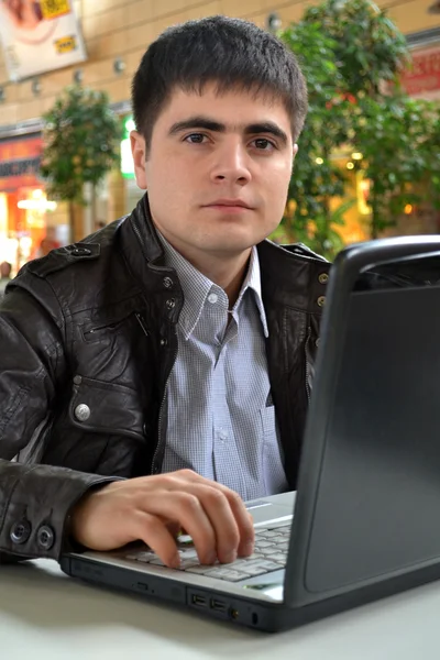 Hombre joven casual con su computadora portátil — Foto de Stock