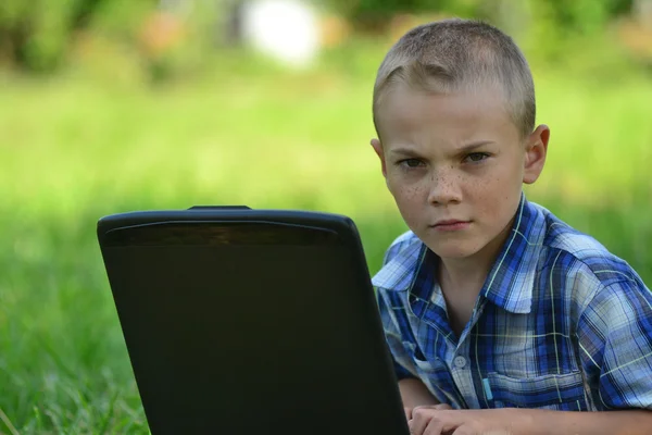 Boy with a laptop in the park — Stock Photo, Image
