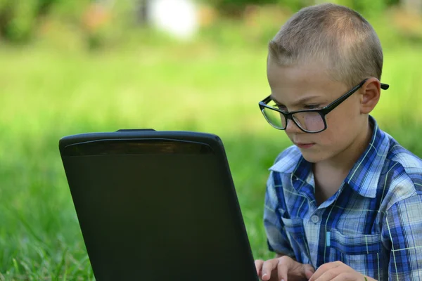 Boy with a laptop in the park — Stock Photo, Image