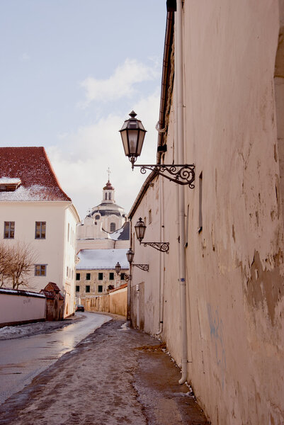 View of Vilnius oldtown street architecture. Illuminators on wall of building. Church.