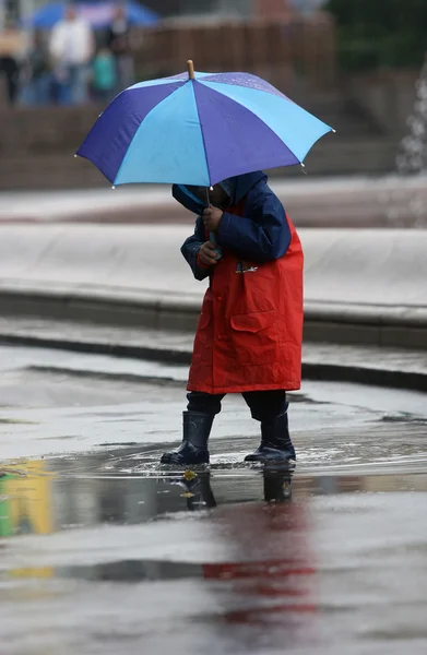 Lapsi sateisena päivänä — kuvapankkivalokuva