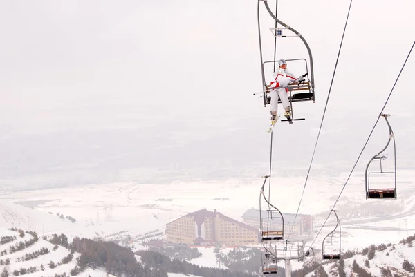 Mooie skiër lift omhoog op stoeltjeslift — Stockfoto