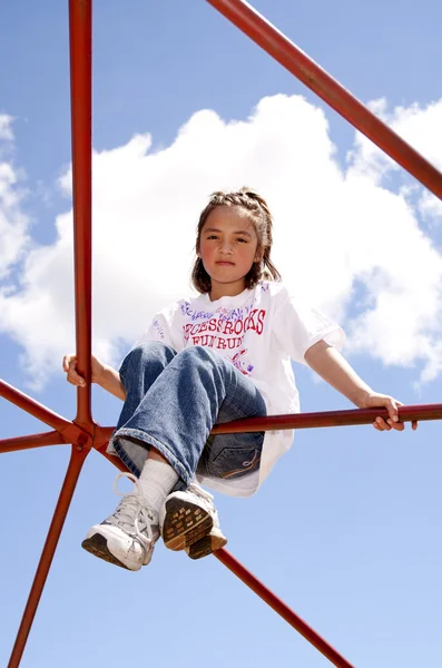 Mädchen sitzt hoch am Stufenbarren. — Stockfoto