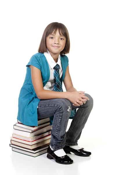 Student sitzt auf Büchern. — Stockfoto