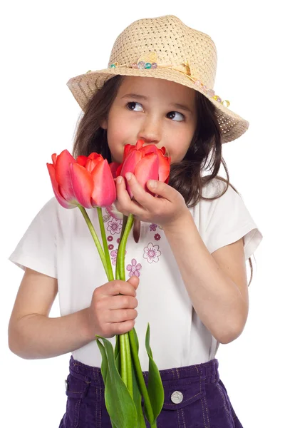 Träumendes kleines Mädchen mit roten Tulpen — Stockfoto