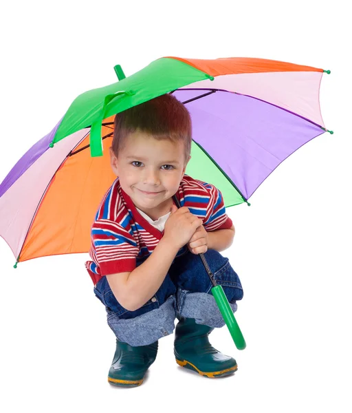 Kleiner Junge sitzt unter Regenschirm — Stockfoto