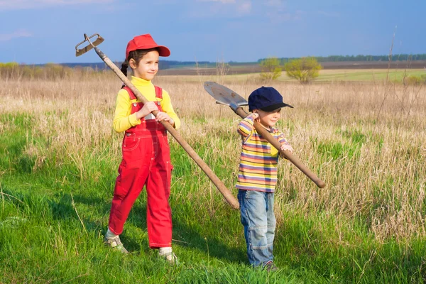 Двое маленьких детей ходят с инструментами — стоковое фото