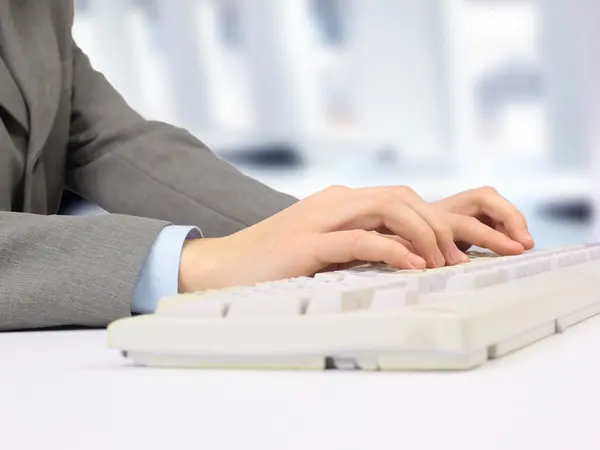 笔记本电脑键盘上的手。在白色背景上孤立 — 图库照片