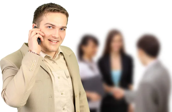 Young smiling businessman calling on phone at office — Stock Photo, Image