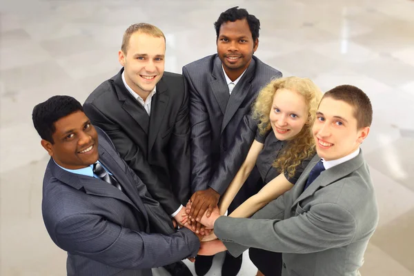 Retrato da equipe de negócios amigável mantendo suas mãos em cima umas das outras — Fotografia de Stock