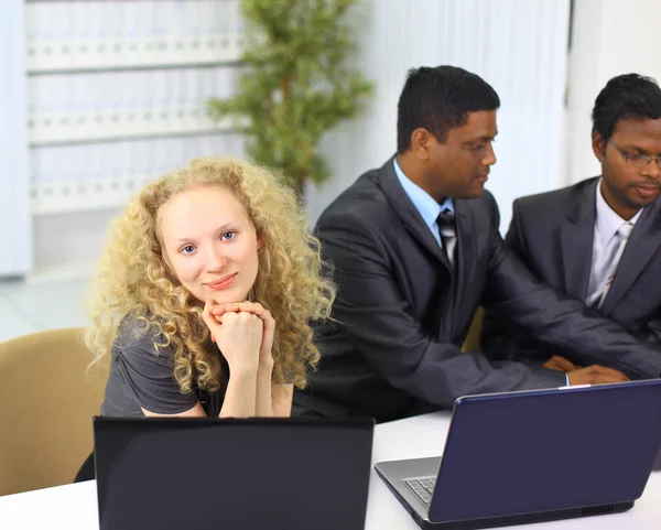 Межрасовая бизнес-команда работает за ноутбуком в современном офисе — стоковое фото