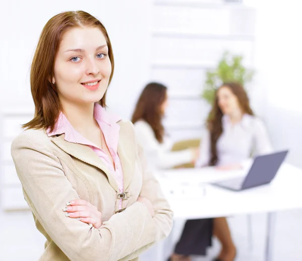 Erfolgreiche Geschäftsfrau steht mit ihren Mitarbeitern im Hintergrund im Büro — Stockfoto