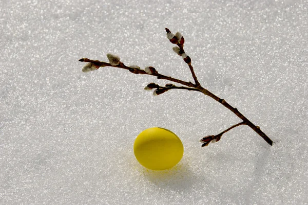 ไข่อีสเตอร์สีเหลืองบนหิมะฤดูใบไม้ผลิ — ภาพถ่ายสต็อก
