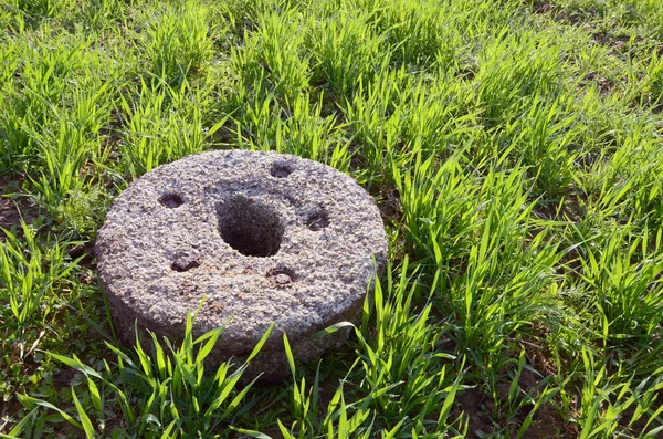 Starý mlýnský kámen na zimní jarní pole — Stock fotografie