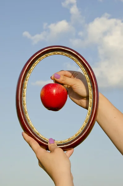 Frauenhände mit Rahmen und Apfel — Stockfoto