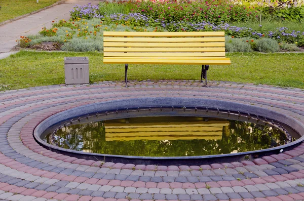 黄色のベンチと小さな池 — ストック写真