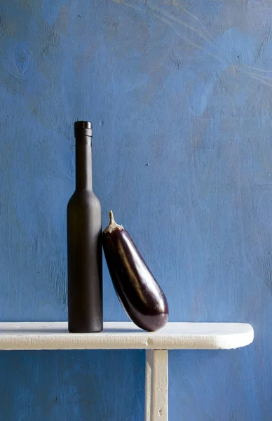 Stilleven met zwarte fles en aubergine — Stockfoto