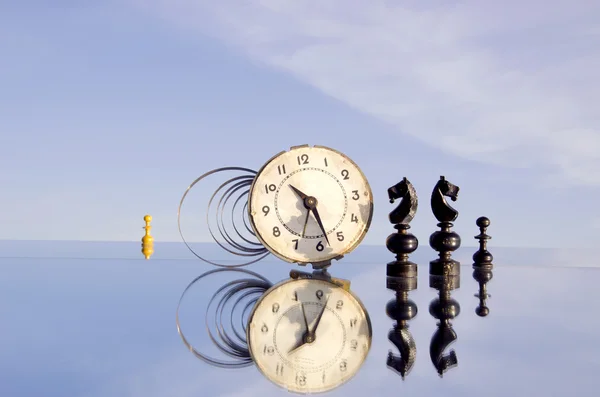 Oldtimer-Uhr und Schachfiguren auf Spiegel — Stockfoto