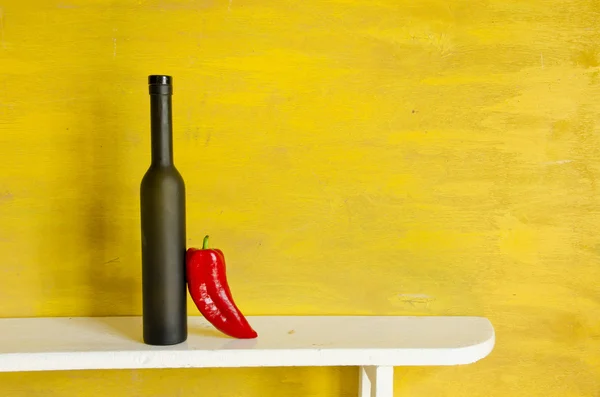 Svart flaska och röd paprika — Stockfoto