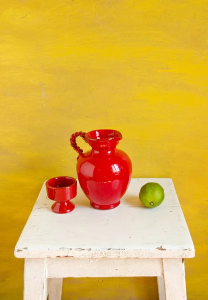 Zátiší s červenou vázu a citronem — Stock fotografie